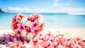 Heart shaped bouquet of pink frangipani and white roses on sandy shore