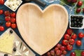 Heart shaped bowl, tasty red wine and snacks on blue wooden table, flat lay Royalty Free Stock Photo