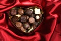 Heart Shaped Box of Candy on red satin background Royalty Free Stock Photo