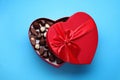 Heart shaped box with delicious chocolate candies on light blue background, top view Royalty Free Stock Photo