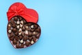 Heart shaped box with delicious chocolate candies on light blue background, top view. Space for text Royalty Free Stock Photo