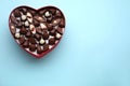 Heart shaped box with delicious chocolate candies on light blue background, top view. Space for text Royalty Free Stock Photo