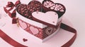 A heart-shaped box with three compartments filled with Valentine\'s Day candies and a message inside