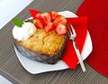 A heart-shaped cake on a white plate and a red mat is on the wooden table Royalty Free Stock Photo