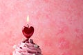 Heart shaped candle burning on cupcake, valentine`s day concept