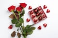 Heart shaped chocolate candies and bouquet on white background, top view Royalty Free Stock Photo