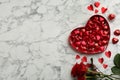 Heart shaped chocolate candies and bouquet on white marble table  flat lay. Space for text Royalty Free Stock Photo