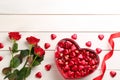 Heart shaped chocolate candies and bouquet on white wooden table, flat lay. Space for text Royalty Free Stock Photo