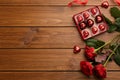 Heart shaped chocolate candies and bouquet on wooden table, flat lay. Space for text Royalty Free Stock Photo