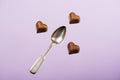 Heart shaped chocolate candies and spoon isolated on pink Royalty Free Stock Photo