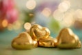 Heart shaped chocolates in golden foil on an old green table. Dark blurred background with bokeh. Wedding greeting