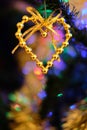 Heart shaped Christmas ornament hanging on a nicely decorated Christmas tree Royalty Free Stock Photo