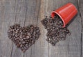 heart shaped in coffee beans and a spilled red cup full of beans