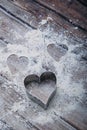 Heart-shaped cookie cutter and flour scattered on the kitchen table with copy space Royalty Free Stock Photo