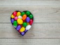 Heart shaped cookie cutter with jelly beans on wood background Royalty Free Stock Photo