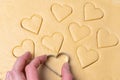 Heart shaped cookie cutters cutting out holiday. Cutting out heart shaped cookies from dough. Royalty Free Stock Photo
