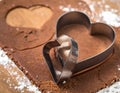Heart-shaped cookie cutters on rolled gingerbread dough with flour heart shape baking Royalty Free Stock Photo