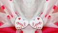 A heart shaped cookie with the word Love on a beautiful Fabric White and Red Background Royalty Free Stock Photo