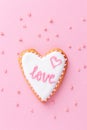 Heart shaped cookie with word LOVE on pink background