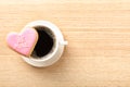 Heart shaped cookie with written phrase Be Mine and cup of coffee on wooden background, top view