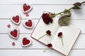 Heart shaped cookies with empty notebook and roses on white wooden background for Valentines day. Royalty Free Stock Photo