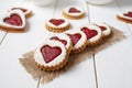 Heart shaped cookies with jam, delicious homemade holiday surprise sweet on white wooden background for Valentines day