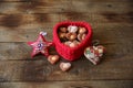 Heart-shaped cookies in a red heart-shaped basket decorative star and heart on a wooden background with copy space for text