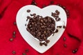 Heart shaped cup with coffee beans on red Royalty Free Stock Photo