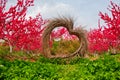 Heart shaped decoration made of straw and blooming red peach blossoms Royalty Free Stock Photo