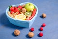 Heart shaped dish with vegetables on wooden background Royalty Free Stock Photo