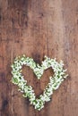 Heart shaped flower wreath on rustic background