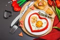 Heart-shaped fried egg served with toasted bread. Romantic art food idea for Valentine\'s breakfast Royalty Free Stock Photo