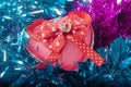 Heart shaped gift box with ribbon and bow on a tinsel background Royalty Free Stock Photo