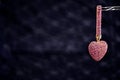 Heart-shaped gift color in rose-gold on a black background shini