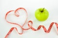 Heart shaped green apple with tape measure Royalty Free Stock Photo