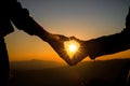 Heart shaped hands on hill at the sunset time Royalty Free Stock Photo