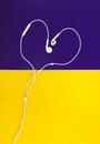 Heart shaped headphones on yellow purple background top view Royalty Free Stock Photo