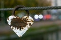 Heart shaped heavy rusty antique lock on urban street background. Vintage padlock on rope. Romantic love concept, fading away feel Royalty Free Stock Photo