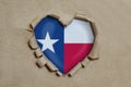 Heart shaped hole torn through paper, showing Texas flag Royalty Free Stock Photo