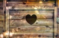 Heart shaped hole on a wooden toilet door Royalty Free Stock Photo