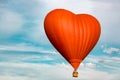 heart shaped hot air balloon on blue sky background with white clouds Royalty Free Stock Photo