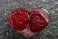 heart shaped ice cube with raspberries trapped inside, macro shot Royalty Free Stock Photo