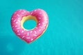 Heart shaped inflatable ring floating in swimming pool on sunny day, above view