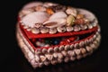 Heart shaped jewelry box decorated with seashells on a black background Royalty Free Stock Photo