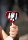 Heart-shaped lollipop in child's hand