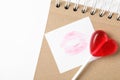 Heart shaped lollipop, notebook and paper note with lipstick kiss on white background, flat lay. Valentine`s day celebration Royalty Free Stock Photo