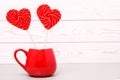 Heart shaped Lollipop in red Cup, for Valentine`s day on white wooden background. Greeting card Royalty Free Stock Photo