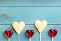 Heart shaped lollipops made of chocolate and sugar syrup on turquoise wooden table, flat lay. Space for text Royalty Free Stock Photo