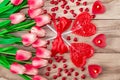 Heart shaped lollipops on wooden background with heart shaped candles lined with tulips flowers. Festive background Royalty Free Stock Photo