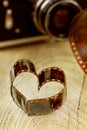 Heart shaped made from retro film negative on wooden board with bokeh from vintage camera Royalty Free Stock Photo